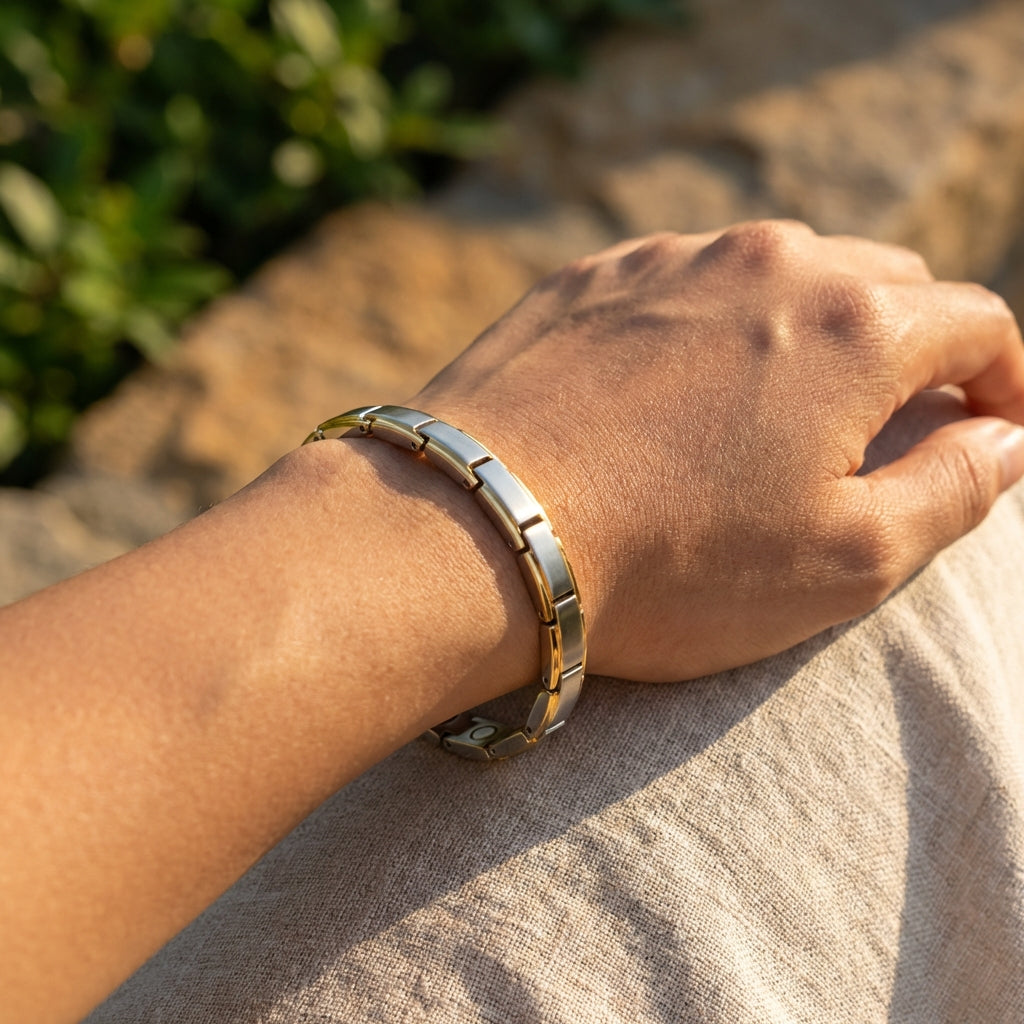Hand wearing a gold bracelet with a natural background