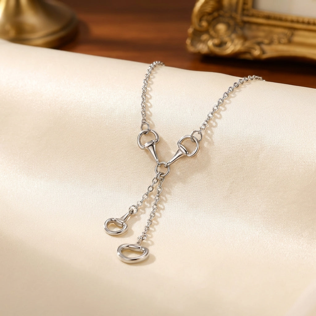 Silver necklace with horsebit clasp on a soft surface