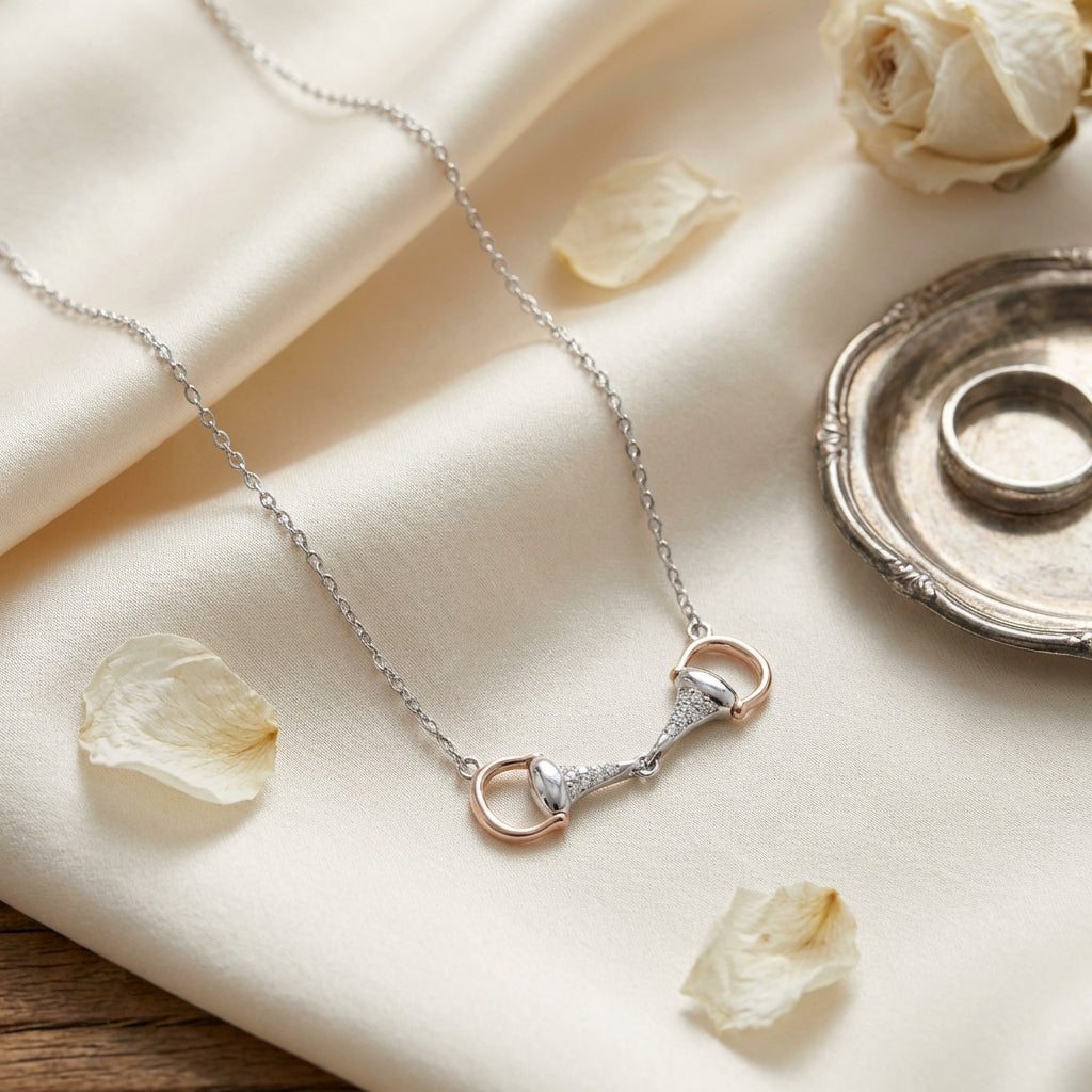 Necklace with a rose gold and silver clasp on a soft beige fabric background